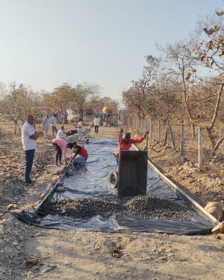 Workers laying a path base with gravel at a dry site, documented during fieldwork